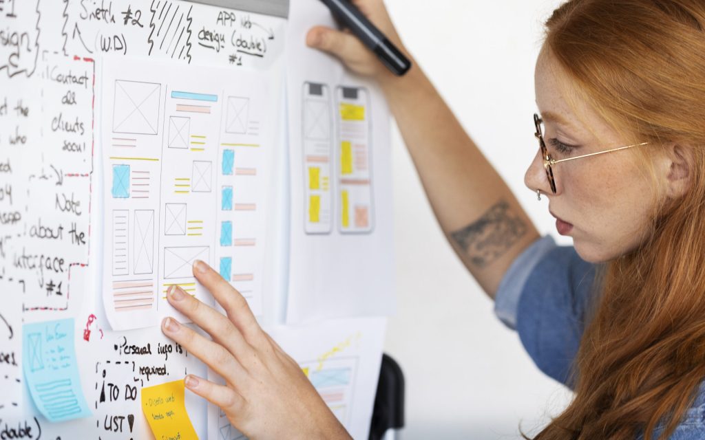 female-web-designer-with-papers-notes-office
