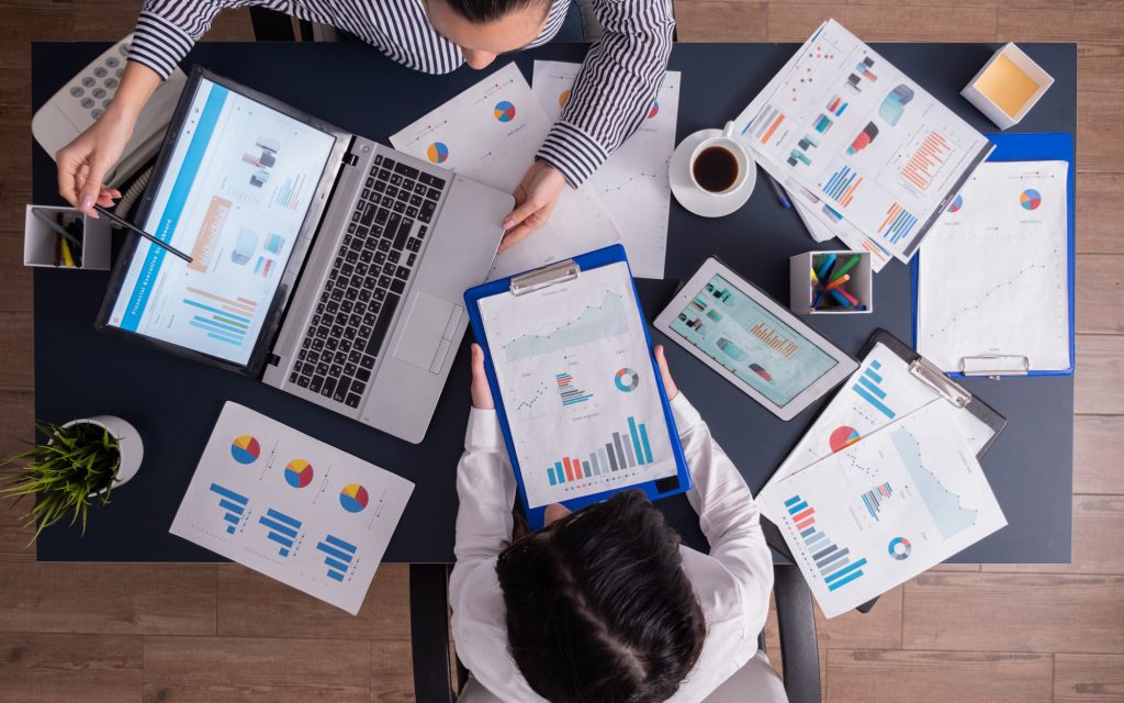 top-viewtop-view-manager-employee-doing-teamwork-business-office-looking-charts-laptop-display